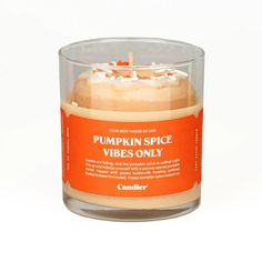 a candle that is inside of a glass cup on a white surface with the label pumpkin spice vibes only