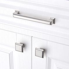 a white cabinet door with two knobs on it