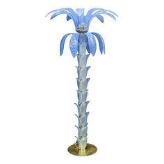 a blue glass palm tree on a gold base with an ornate crown atop the top