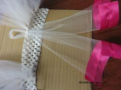 the bride's veil is wrapped in white tulle and pink satin ribbon, along with matching shoes