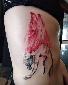 a woman's stomach with a red hair and an image of a fish on it