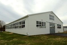 a large white building sitting on top of a lush green field