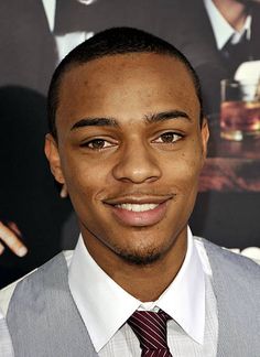 a man in a vest and tie smiling at the camera