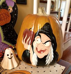 two pumpkins with cartoon characters on them sitting on a table next to each other