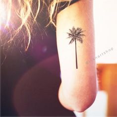 a small palm tree tattoo on the arm