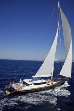 a sailboat sailing in the ocean on a sunny day