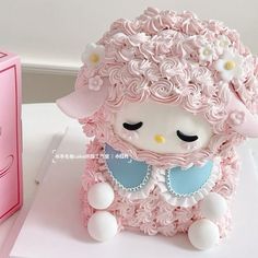 a cake shaped like a sheep with flowers on its head