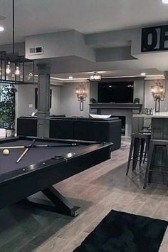 a pool table in the middle of a room with bar stools and an island