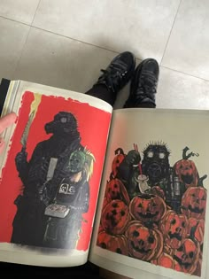 the person is holding an open book in their hand and there are pumpkins on the floor