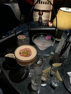 a table topped with glasses filled with different types of drinks and food on top of it