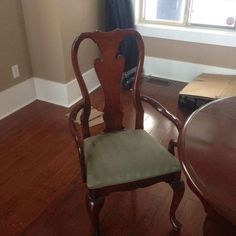 a wooden chair sitting in front of a window on top of a hard wood floor