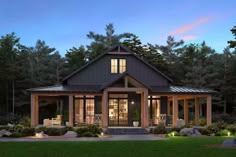 a house is lit up at night with lights on the front porch and covered patio