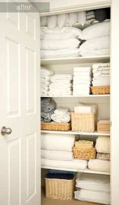 an organized closet with folded towels, baskets and linens on shelves next to the door