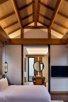 a large bed sitting under a wooden ceiling