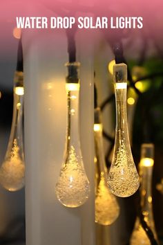 three light bulbs with water drop solar lights hanging from the ceiling in front of them