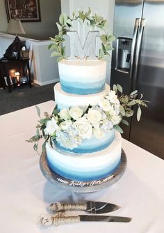 a three tiered cake sitting on top of a table next to a knife and fork