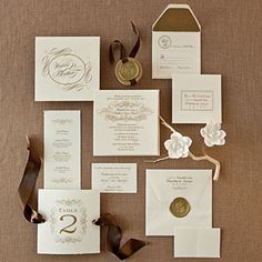 the wedding stationery is laid out on top of each other with ribbons and paper