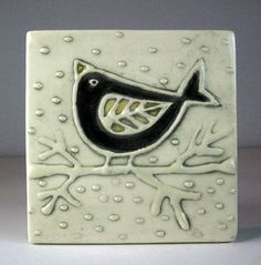 a ceramic tile with a bird on it