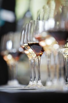 several glasses of wine are lined up on a table