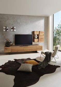 a living room filled with furniture and a flat screen tv on top of a wooden stand