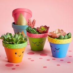 four potted plants with faces painted on them and polka dot dots around the edges