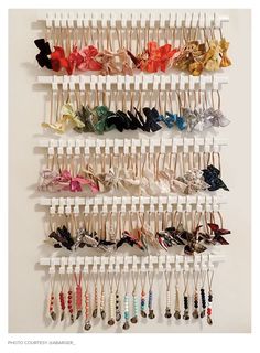 a wall mounted rack with several pairs of hair clips