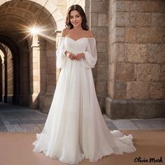 a woman in a white wedding dress posing for the camera with her hands on her hips