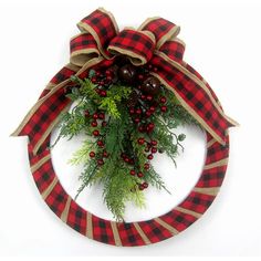 a red and black plaid wreath with pine cones, berries and evergreens on it