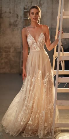 a woman in a wedding dress standing next to a stair case