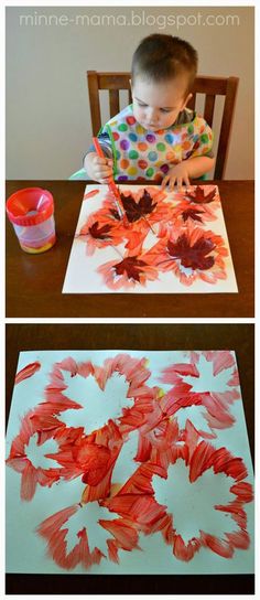 a child is sitting at a table and painting leaves on paper