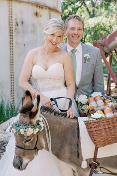 a bride and groom are sitting on a donkey