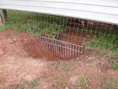 a hole in the ground next to a fence