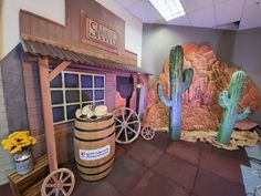 a fake cactus sits in the corner of a room next to a barrel and other items