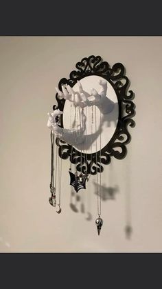 a black and white clock hanging from the side of a wall next to a mirror