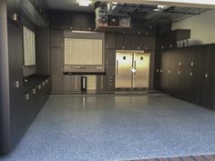 an empty kitchen with stainless steel refrigerators and cabinets in the middle of the room