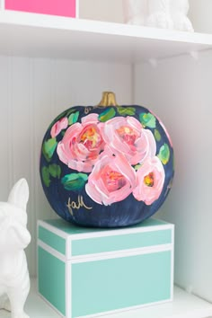 a painted pumpkin sitting on top of a blue box