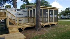 a mobile home with stairs leading to the porch and second story deck in front of it