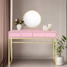 a pink and gold desk with a mirror on it next to a potted plant