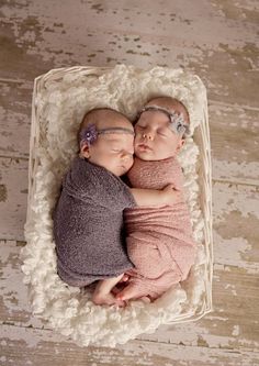 two newborn babies are sleeping in a basket