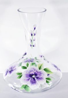 a glass vase with purple flowers painted on it