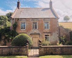 an old brick house with ivy growing on it's walls and gated yard