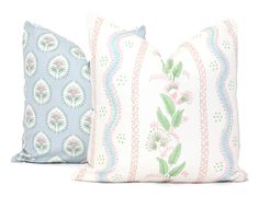 two pillows sitting next to each other on a white surface