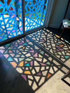 the sun shines through stained glass windows in a room with wooden floors and walls