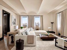 a living room filled with furniture and tall windows