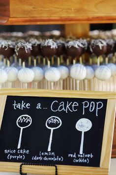 there is a sign that says take a cake pop in front of some cupcakes