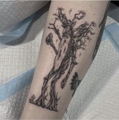 a tattoo on the leg of a person with a tree