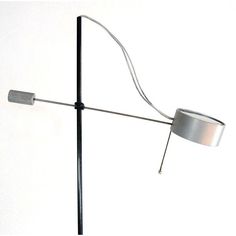 a lamp that is on top of a metal pole with a light attached to it