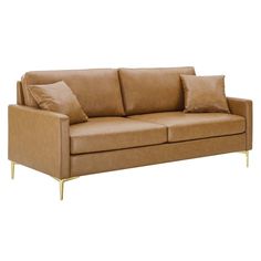 a tan leather couch with gold legs and pillows on it's backrests