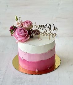 a birthday cake decorated with pink and white frosting, flowers and a happy 30th sign