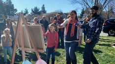 a group of people standing around an easel